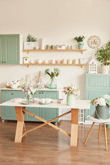 bright kitchen in the style of Provence, on the table dishes and a bouquet of flowers in a vase