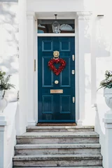 Blaue Haustür mit rotem Herzschmuck an der Fassade eines traditionellen englischen Hauses in London, Großbritannien. © Alena