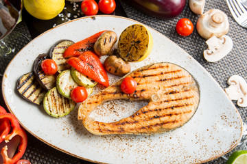 Grilled salmon steak. Fried vegetables: zucchini, tomato, eggplant, onion, pepper