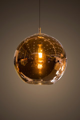 Modern streamlined mirror round copper chandelier. Bubble glass transparent pendant light. Isolate on dark background