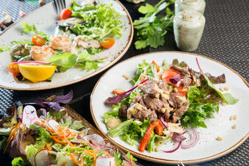Meat salad with fresh vegetables. Table setting in the restaurant