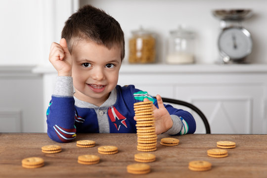 Little boy making a stack of cookie