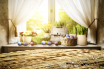 Wooden table of free space for your decoration. Spring window background. Easter eggs and flowers on window sill. 