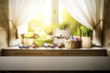 Wooden table of free space for your decoration. Spring window background. Easter eggs and flowers on window sill. 