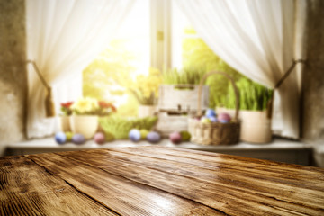 Wooden table of free space for your decoration. Spring window background. Easter eggs and flowers on window sill. 