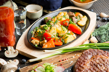 Tasty roast of vegetables and meat with tomato juice. Tomato juice in a glass.