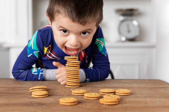 Funny boy eating a stack of cookie