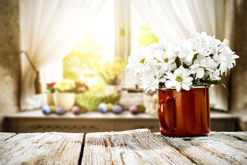 Wooden table of free space for your decoration. Spring window background. Easter eggs and flowers on window sill. 