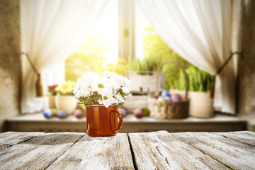 Wooden table of free space for your decoration. Spring window background. Easter eggs and flowers on window sill. 