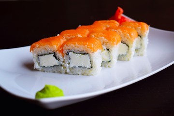 Delicious fresh rolls, Philadelphia, on white plate and black background.