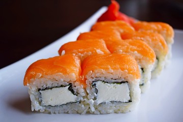 Delicious fresh rolls, Philadelphia, on white plate and black background.