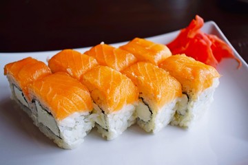 Delicious fresh rolls, Philadelphia, on white plate and black background.