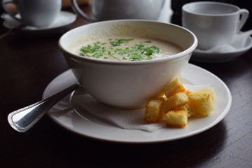 Delicious mushroom cream soup with crackers in a white plate.