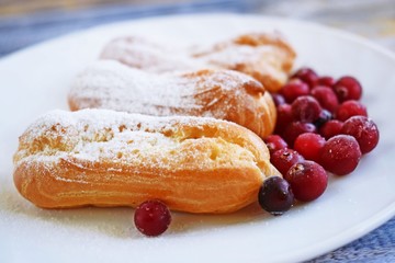 Custard tarts and fresh berries on a white plate.