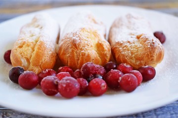 Custard tarts and fresh berries on a white plate.
