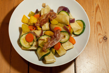 dish with swabian pocket pasta squares, vegetables and bacon