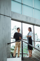 partners of business chatting about collaboration for next project on the stairs in the office building