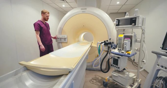 Caucasian doctor checking MRI scanner bed