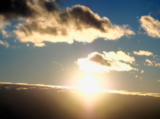 Dramatic atmospheric front of clouds during burning sunset background