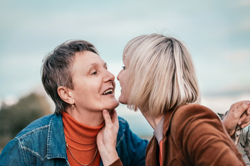 Fototapeta premium Elderly mother tenderly kissing his daughter. Concept - Maternal love and family