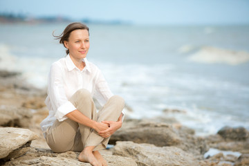 Young woman enjoying life on the ocean coast