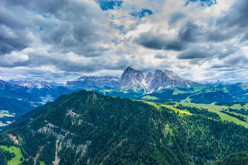 Fototapeta premium Alpe di Siusi, Seiser Alm with Sassolungo Langkofel Dolomite, a view of a large mountain in the background