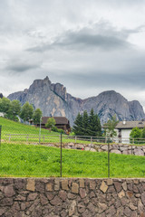 Alpe di Siusi, Seiser Alm with Sassolungo Langkofel Dolomite, a stone building with a mountain in the background