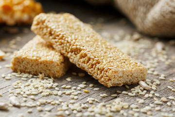 Sesame seed casinos on old vintage background with burlap cloth. Country style. Delicious sweets from seeds of sunflower, sesame and peanuts, covered with shiny glaze