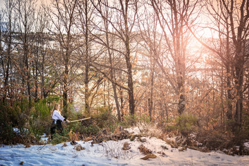 Female warrior. Woman with wooden sword practicing aikido in the snow