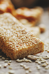 Sweets Bar of sesame on a vintage background with burlap. Delicious oriental sweets Gozinaki from sunflower seeds, sesame and peanuts, covered with honey with a shiny icing