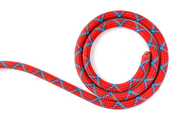 Sport climbing rope, coiled in a circle, isolated on a white background. 10mm mountaineering dynamic rope showing one end only and a few coil laps, with a blue on red pattern.