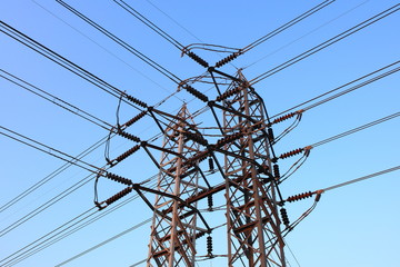 Branching power line high voltage pole high-voltage tower with blue sky background.