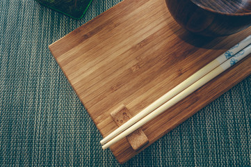 bamboo board with wooden chopsticks and bowl