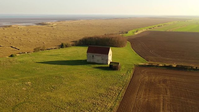 Aerial sequence featuring The Chapel of St Peter-on-the-Wall, Bradwell-on-Sea, Essex. It is a Grade I listed building and among the oldest largely intact Christian churches in England, built in 660.