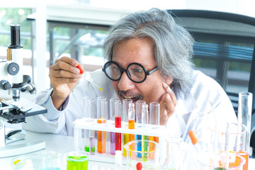 Professor research scientist preparing and analyzing pipetting solution into the glass in research laboratory.