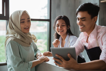 a hijab woman order food and drink to waitress in the cafe
