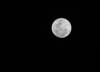 The full moon on the night sky in black and white tone