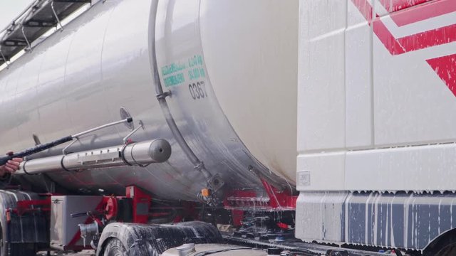 Worker washes a truck with huge chester