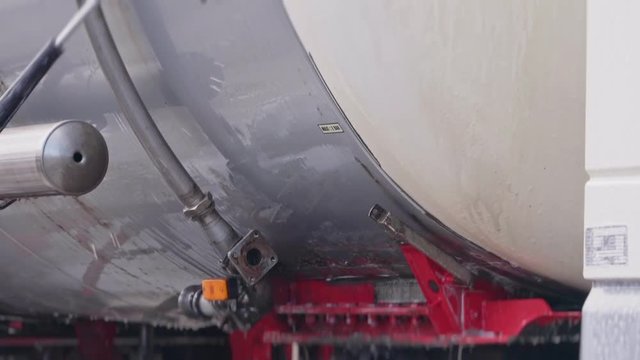 Worker washes a truck with a huge chester close-up