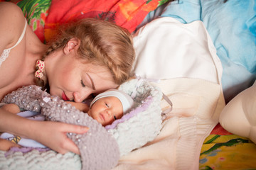 Obraz na płótnie Canvas Mom sleeps with a newborn. Mom and the child. Breast-feeding. Fatigue.