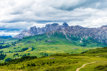 Obraz premium Alpe di Siusi, Seiser Alm with Sassolungo Langkofel Dolomite, a large green field with a mountain in the background