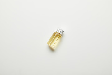 Top view of essential oil in bottle on white surface