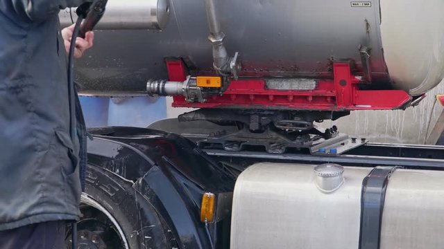 Worker washes truck with a huge chester closeup