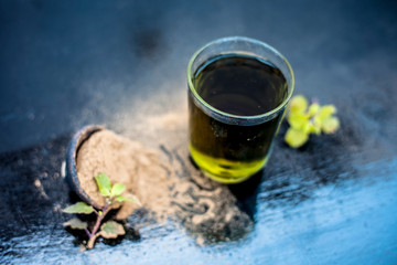 Ayurvedic herb brahmi or Waterhyssop with its herbal and beneficial extract  in a transparent glass along with its powder on wooden surface.
