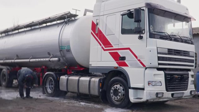 Worker carefully washes a truck with a huge chester