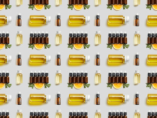 Pattern with various bottles of essential oil and cut orange on grey background