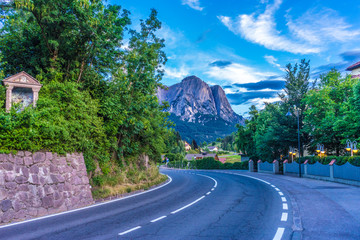 Naklejka premium Alpe di Siusi, Seiser Alm with Sassolungo Langkofel Dolomite, a street scene with focus on the side of a road