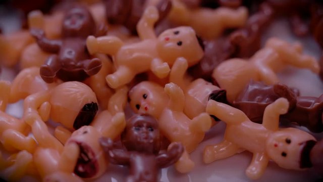 ROTAING PILE OF TOY, PLASTIC BABIES.  ECU SLIDER SHOT.  IN 4K, 10 BIT, ALL-INTRA.