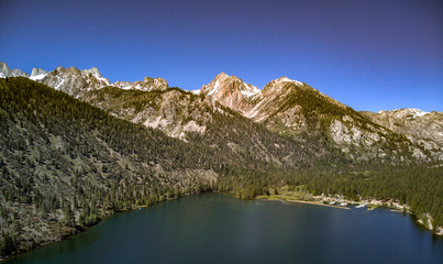 Fototapeta premium Aerial, drone view of Twin Lakes in the Eastern Sierra Nevada Mountains near Yosemite in Mono County, California with clear blue sky and water, snow capped mountain peaks, green hill sides