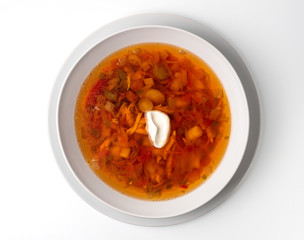 Bowl with chicken, beetroot and other vegetables soup. Perfect bright broth in italian minestrone style, isolated on white. Top view or flat lay.
